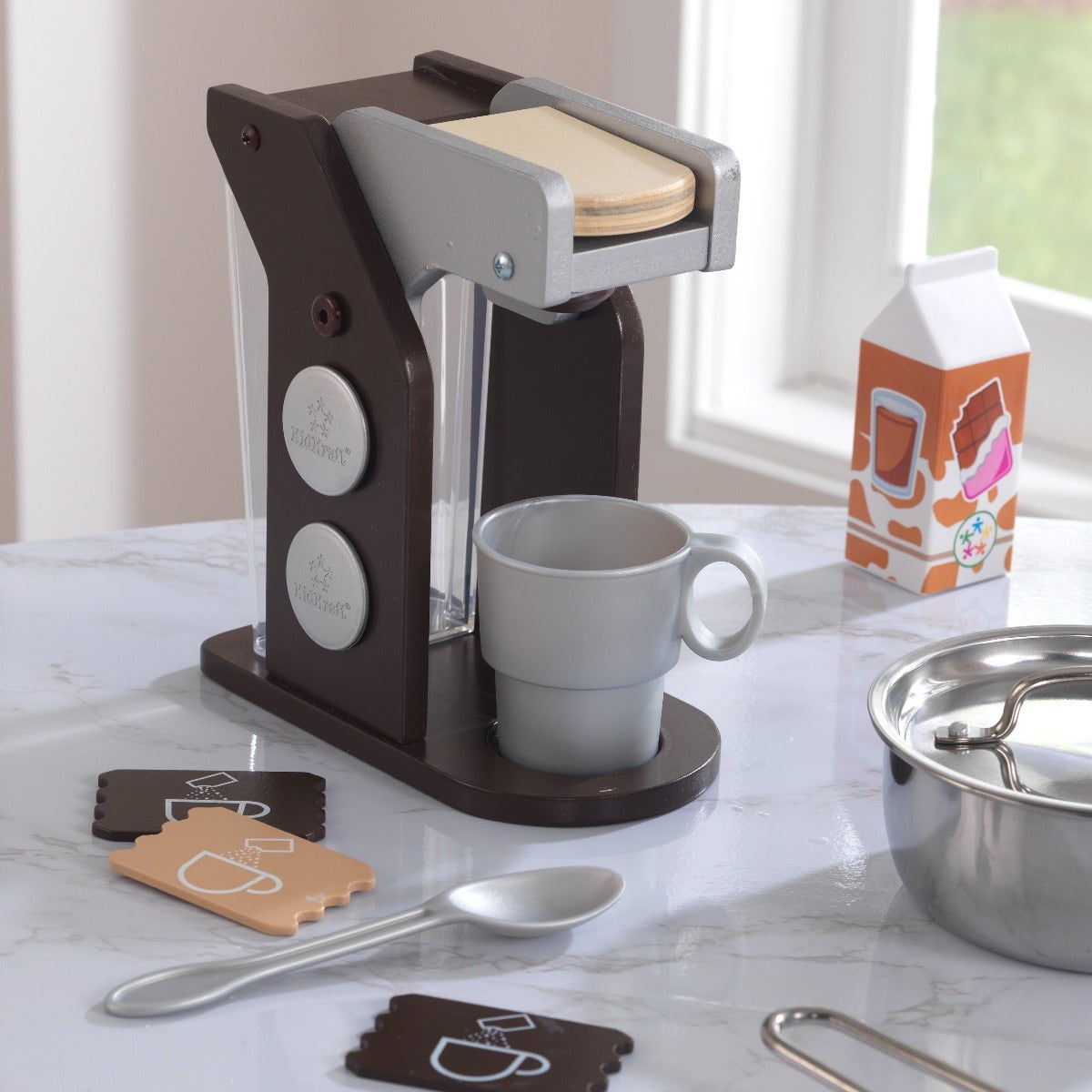 Coffee set includes cup, spoon, sugar packets, milk, and coffee pods