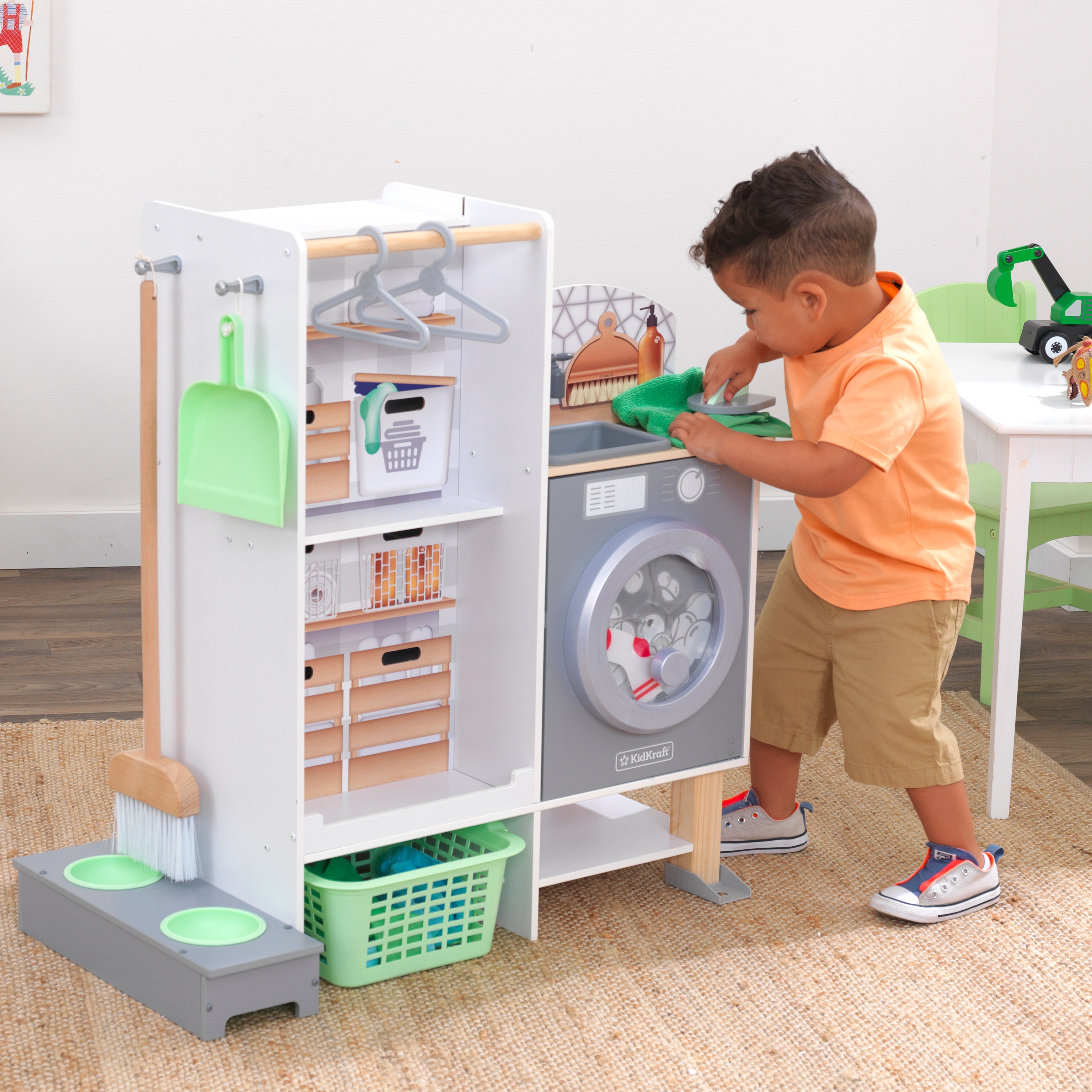 Kid playing with KidKraft washer and kitchen set