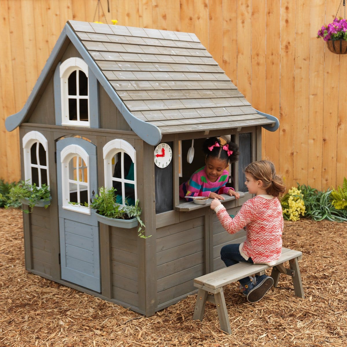 kid playing with KidKraft outdoor playhouse