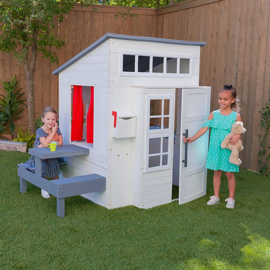 girl playing with KidKraft outdoor playhouse